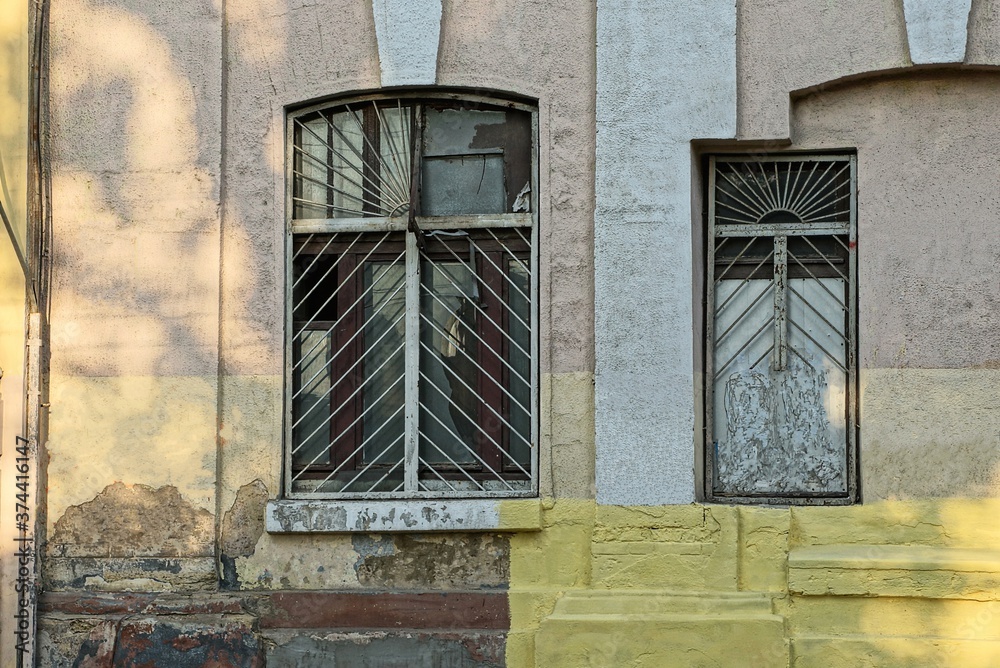 two old windows with a lattice on a brown concrete wall