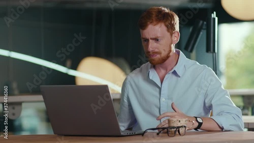 Angry young ginger businessman receiving bad news about his work frustrating sitting inside the cafe. Negative emotions. Failure.