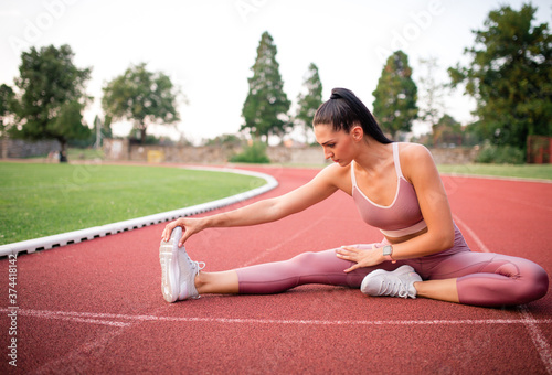 Stretching on the athletic track at the stadium.