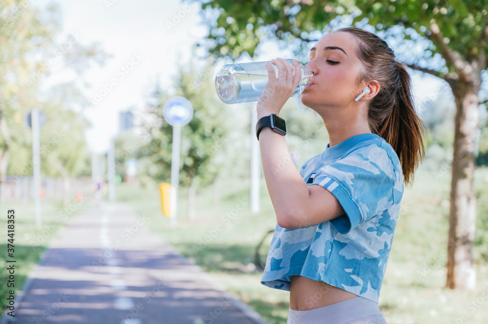 Young woman exercising and drinking water. Young woman exercising and drinking water.