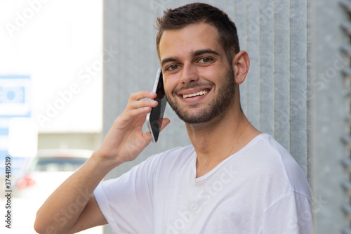 attractive young man with mobile phone on the street
