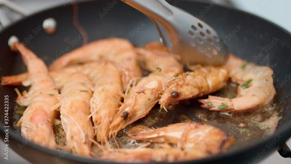 Frying shrimps/prawns, turning to the other side for frying in a pan in 4K. Frying shrimps/prawns, turning to the other side for frying in a pan in 4K.