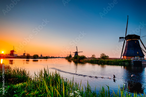 Traditional Romantic Dutch Windmills in Kinderdijk Village in the Netherlands During Golden Hour.