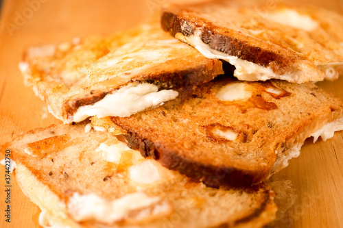 Large Number of Tasty Slices of Traditional Fried Bread With Fried Eggs Together. Over Wooden Board Indoors. photo