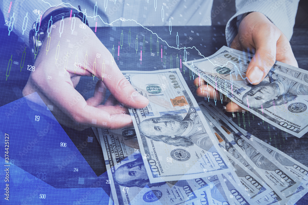 Multi exposure of financial graph drawing hologram and USA dollars bills and man hands. Analysis concept. Multi exposure of financial graph drawing hologram and USA dollars bills and man hands. Analysis concept.