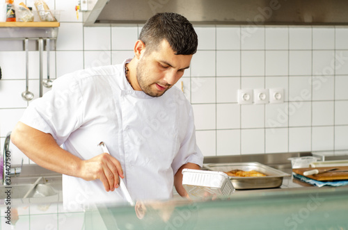 handsome chef  serves food with spoon no hat clipart 
