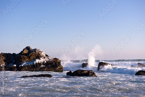 The seascape with huge wave and rocks.