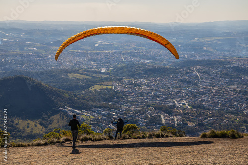 Pessoas praticando voo de parapente. Esporte radical. Descendo pelas Montanhas de paraquedas. Sensação de liberdade. 