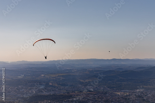 Pessoas praticando voo de parapente. Esporte radical. Descendo pelas Montanhas de paraquedas. Sensação de liberdade. 