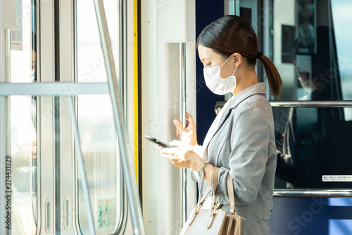 マスク姿で電車通勤をする女性