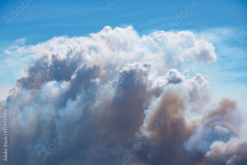 A pyrocumulus cloud forms above smoke rising from an out of control fire. photo