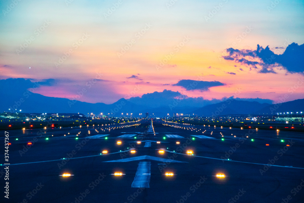 Airfield ground lighting on runway, sunrise time at Hong Kong Airport