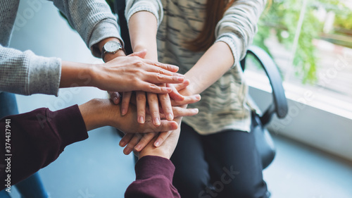 Fototapeta Naklejka Na Ścianę i Meble -  Closeup image of business team standing and joining their hands together in office