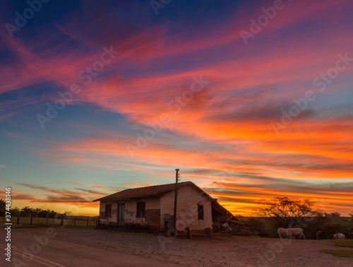 old abandoned house farm in a colourful sunset sky