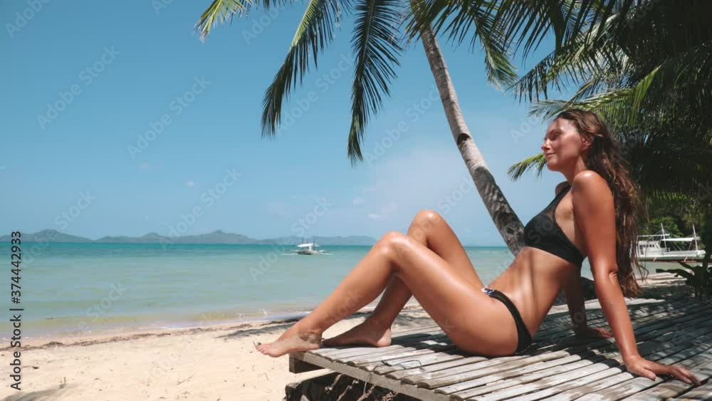 Beach woman sunbathe Philippines, Asia. Traveler girl rest at sun on lounger and admire of exotic nature. Majestic summer vacation in tropic paradise. Cinematic tropical scenery in 4K, UHD Beach woman sunbathe Philippines, Asia. Traveler girl rest at sun on lounger and admire of exotic nature. Majestic summer vacation in tropic paradise. Cinematic tropical scenery in 4K, UHD