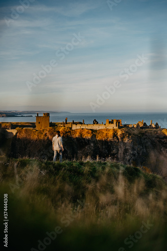 person in front of castle near the sea