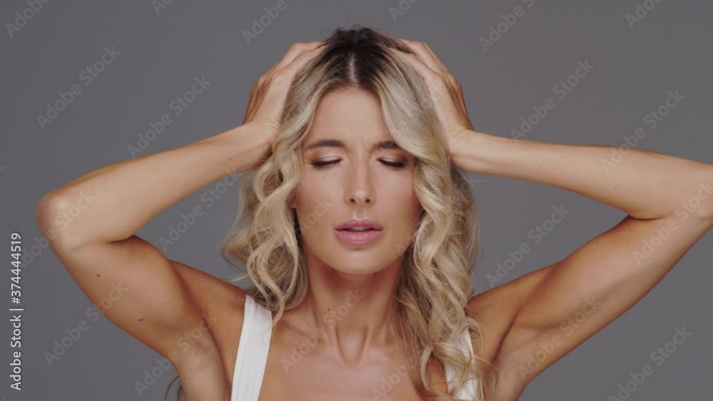 Studio portrait of young and beautiful blond woman over grey background. Studio portrait of young and beautiful blond woman over grey background.