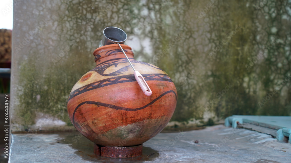 Red Clay pot with stainless steel glass in a house corner. Stylish printed art, ancient India culture to make pot.
 - obrazy, fototapety, plakaty 