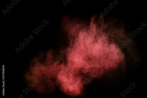 Red and pink powder explosion on black background. Colored powder cloud. Colorful dust explode. Paint Holi.