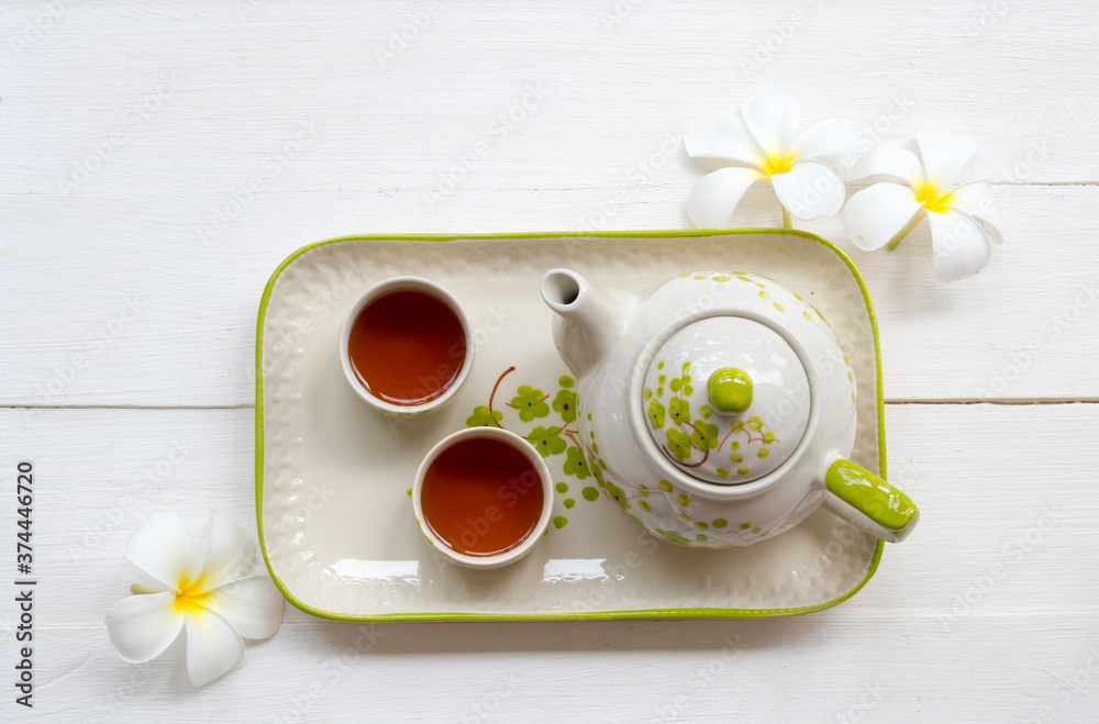 herbal healthy drinks tea for health care sore throat with teapot ,flowers frangipani of lifestyle relax arrangement flat lay style on background white wooden herbal healthy drinks tea for health care sore throat with teapot ,flowers frangipani of lifestyle relax arrangement flat lay style on background white wooden