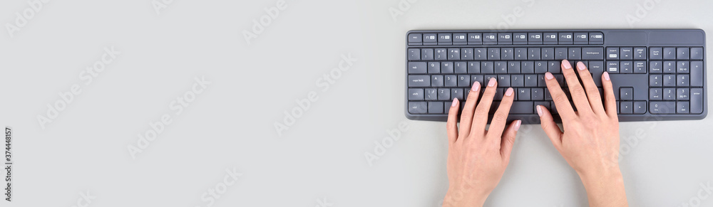 Hands with keyboard on grey background. Flat lay, overhead view image. Hands with keyboard on grey background. Flat lay, overhead view image.