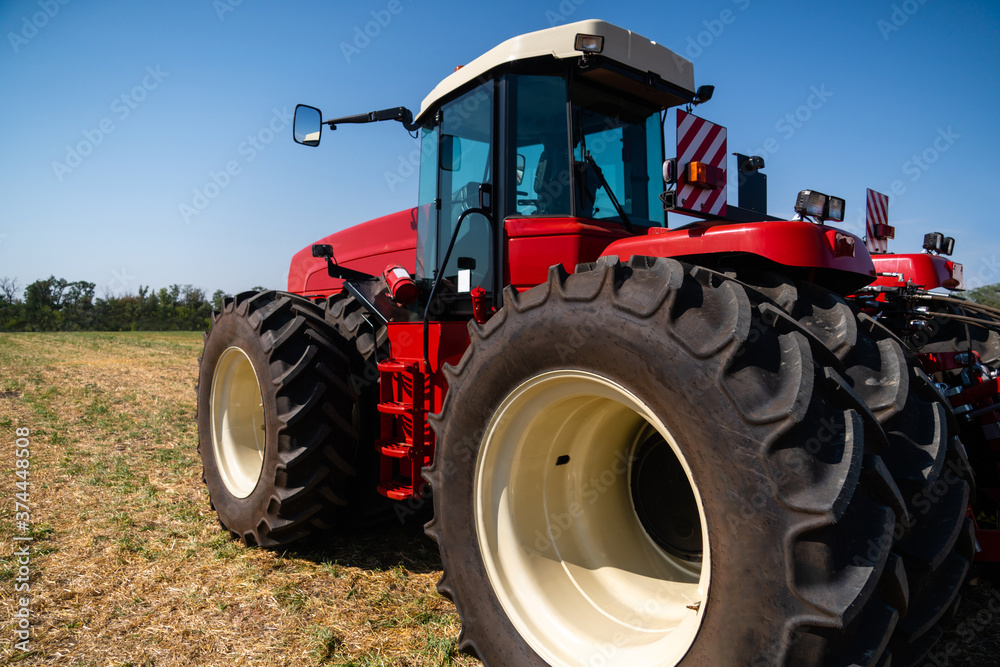 Red tractor on a agricultural field Red tractor on a agricultural field
