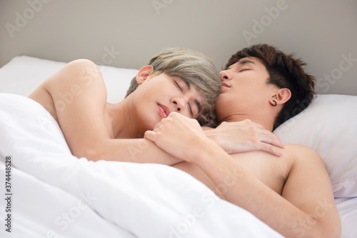 LGBT concept gay couples love Asian men cuddling in bed.