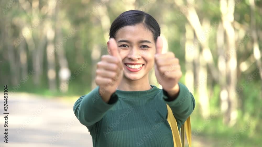 Beautiful Asian positive girl shows thumb up to gesture of approval for success or consent concept. Slow motion. Beautiful Asian positive girl shows thumb up to gesture of approval for success or consent concept. Slow motion.