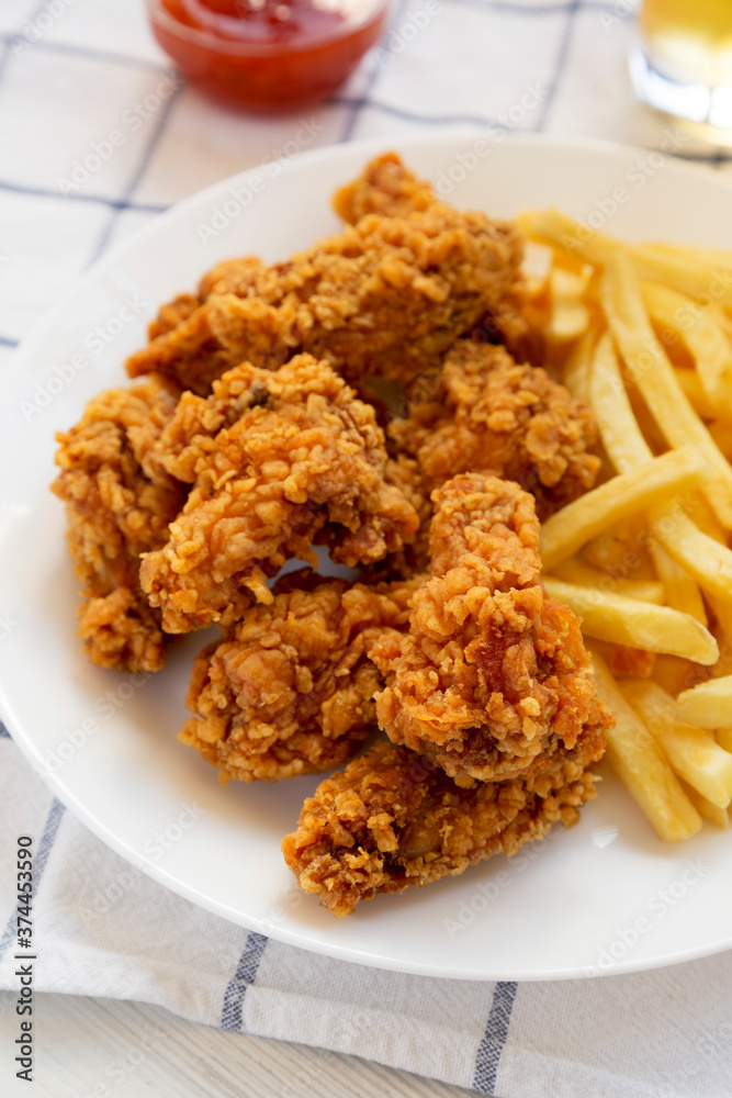 Homemade Crispy Chicken wings and French Fries on cloth, side view. Close-up. Homemade Crispy Chicken wings and French Fries on cloth, side view. Close-up.