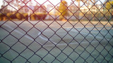 sport empty court with hard surface behind iron fence