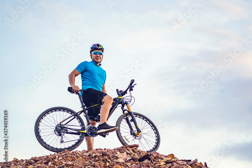 Mountain bikes cyclist cycling, Asian man athlete riding biking on rocky terrain trail track, extreme sport wearing gear uniform helmet, exciting joy freedom outdoor nature healthy active lifestyle