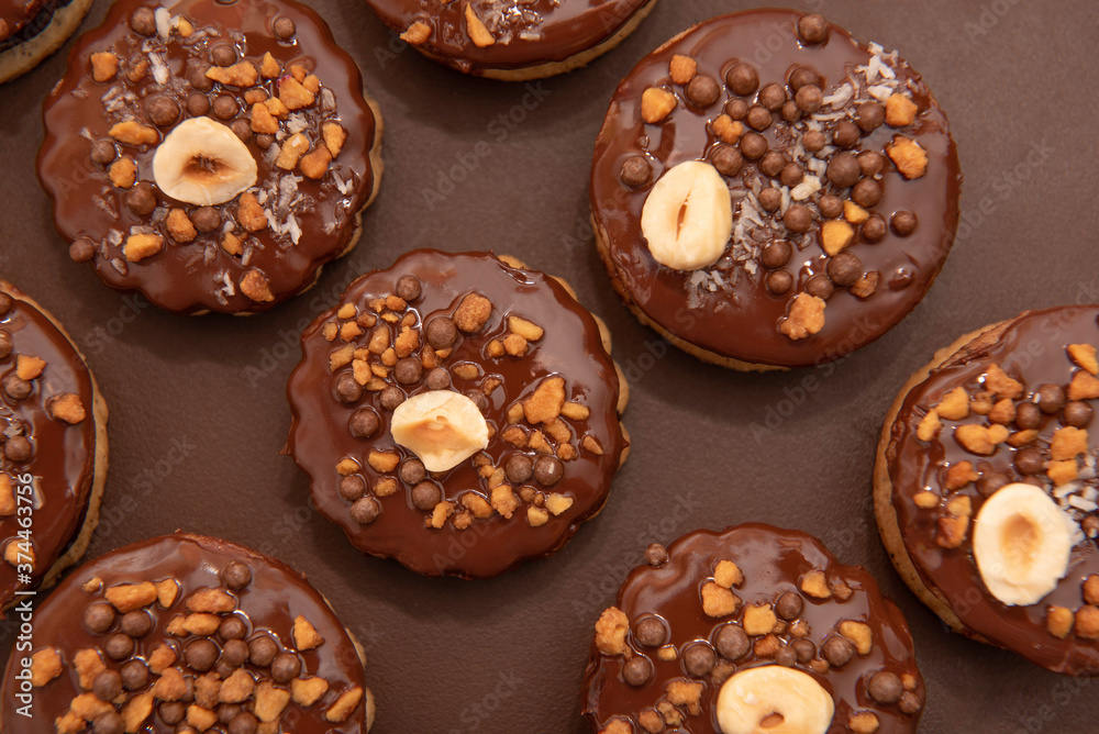 Brown Isler (or Ischler, Ishler) Cookies with hazelnuts and peanut brittle on brown background, dating back to Austro-Hungarian Empire Brown Isler (or Ischler, Ishler) Cookies with hazelnuts and peanut brittle on brown background, dating back to Austro-Hungarian Empire