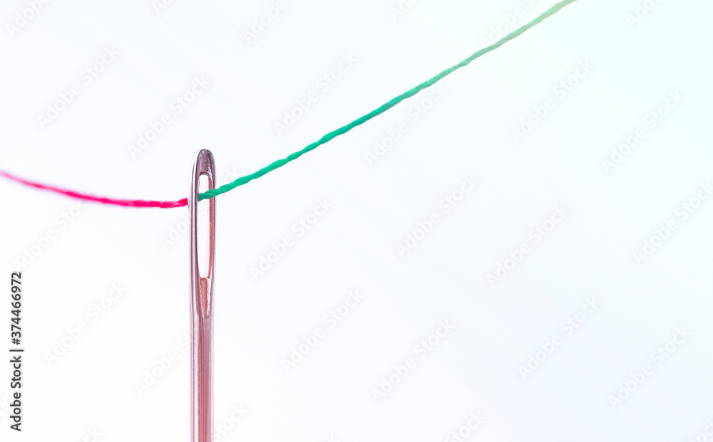 a red thread passes through the needle, a green one comes out. business concept a red thread passes through the needle, a green one comes out. business concept
