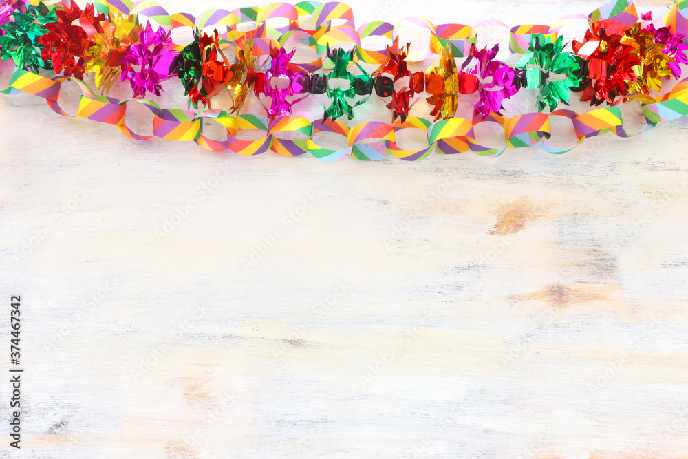 Fototapeta premium Colorful chain garland over white wooden background. Traditional jewish sukkot holiday decoration