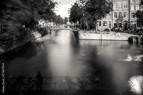 Amsterdam, Holland, the Netherlands - July 6 2020: capture of the typical Amsterdam scenery in black and white with canal, canalo house, clouds and the iconic buildings of the city