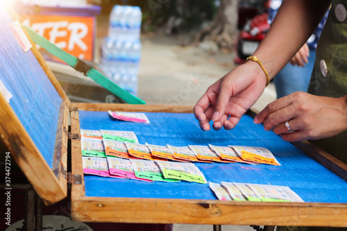 Wat Yai Chimongkol in Ayutthaya, Thailand - Jul 29, 2020  Female hand choosing Thai little lottery leftovers tickets at the Wat Yai Chimongkol in Ayutthaya. The concept of winning a big fortune