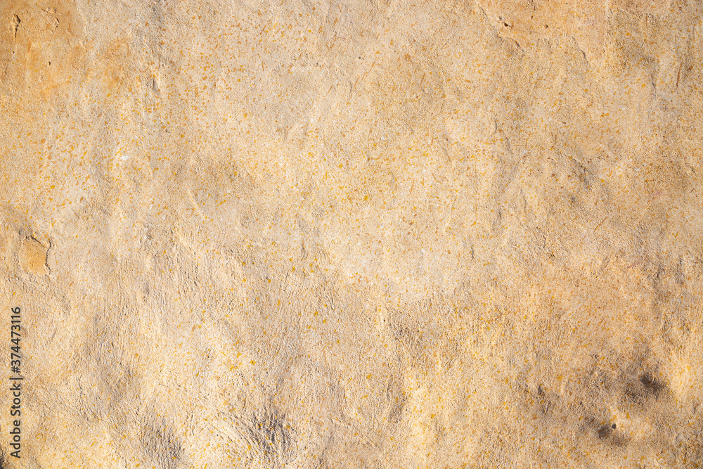 detail of a beige grainy cement wall background 