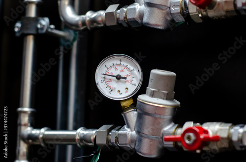 Close up of house heating system with many steel pipes, manometers and metal tubes.