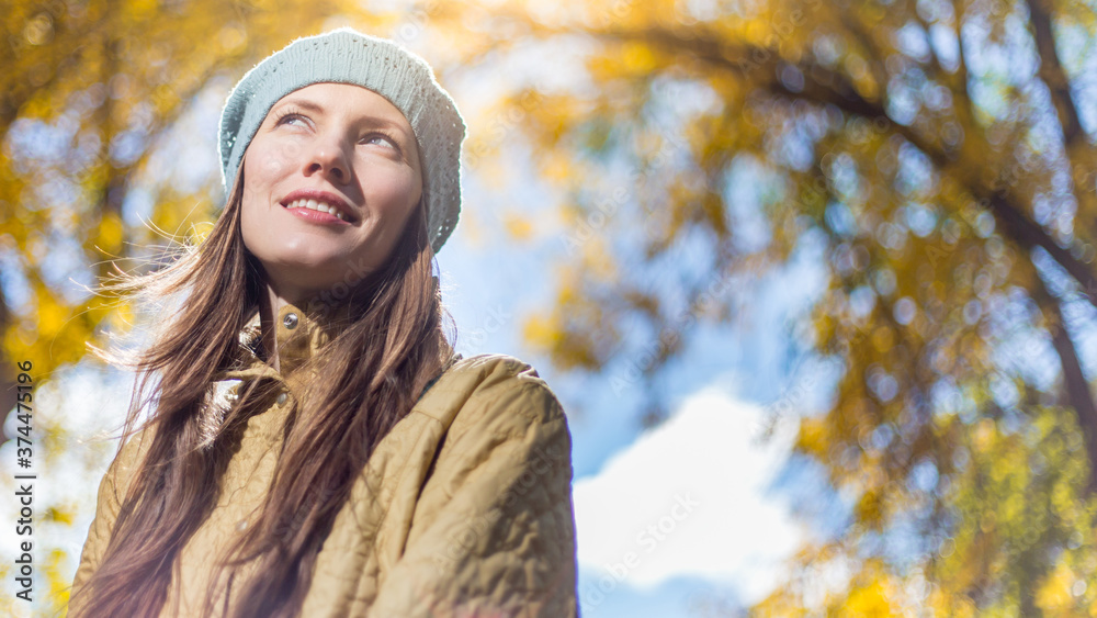 young woman in autumn park wearing warm clothes over golden autumn background young woman in autumn park wearing warm clothes over golden autumn background