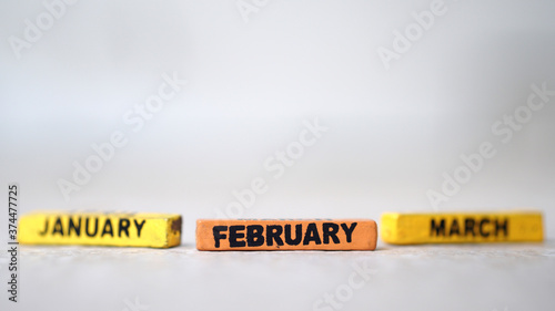 Wooden block calendar with focus on FEBRUARY, January March blur. silver background