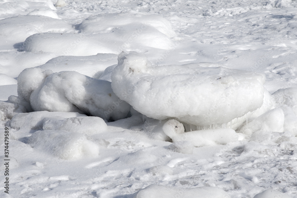 Natural sea ice blocks breaking up against the shore and ice during freezing winter weather. In the background Natural sea ice blocks breaking up against the shore and ice during freezing winter weather. In the background