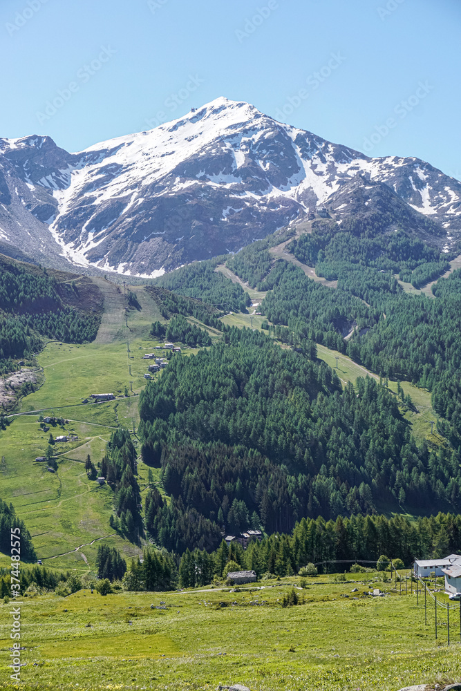 Obraz premium The pastures, the mountains and the nature while hiking above the village of Madesimo, Italy - June 2020.