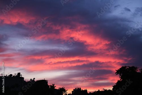 Colorful clouds and city silhouette at sunset