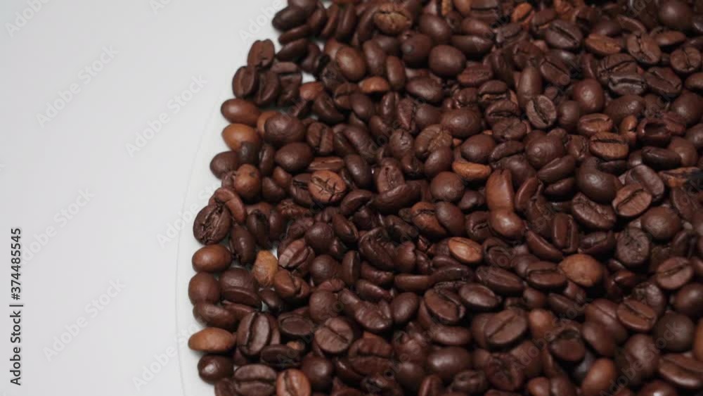 Pile of Dark Roast Coffee Beans, Pan Left to White Background Pile of Dark Roast Coffee Beans, Pan Left to White Background
