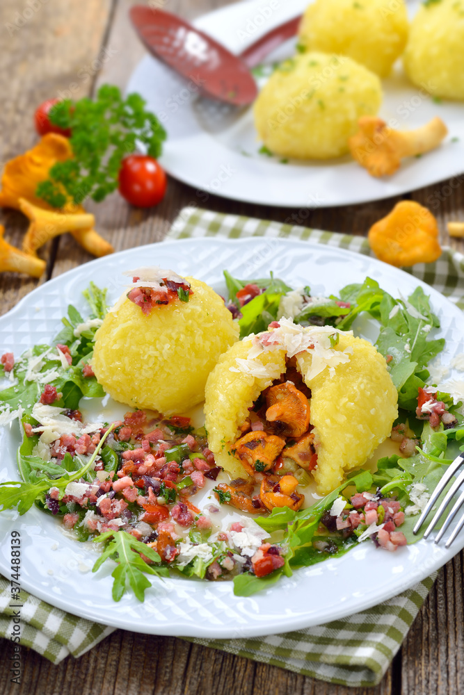 Mit gebratenen Pfifferlingen gefüllte Kartoffelknödel mit Schinken-Sauce an Rucolablättern mit Parmesan – Potato dumplings stuffed with fried chanterelles, served with ham cubes, rucola and cheese