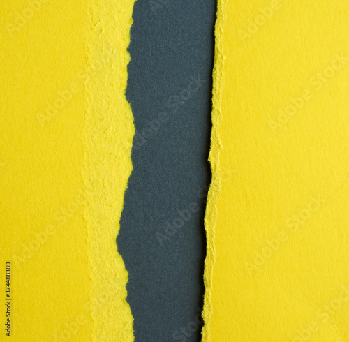 background of layered yellow torn paper with a shadow on a black background