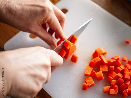 Woman cutting carrot in domestic kitchen
 photo