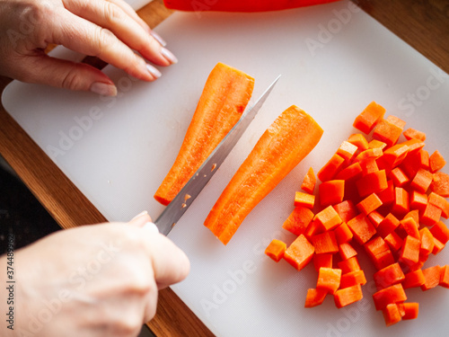 Woman cutting carrot in domestic kitchen 