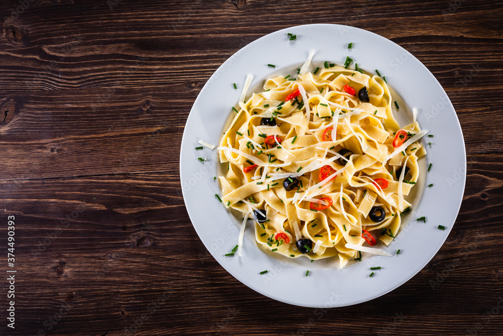 Pasta with parmesan and vegetables on wooden table
