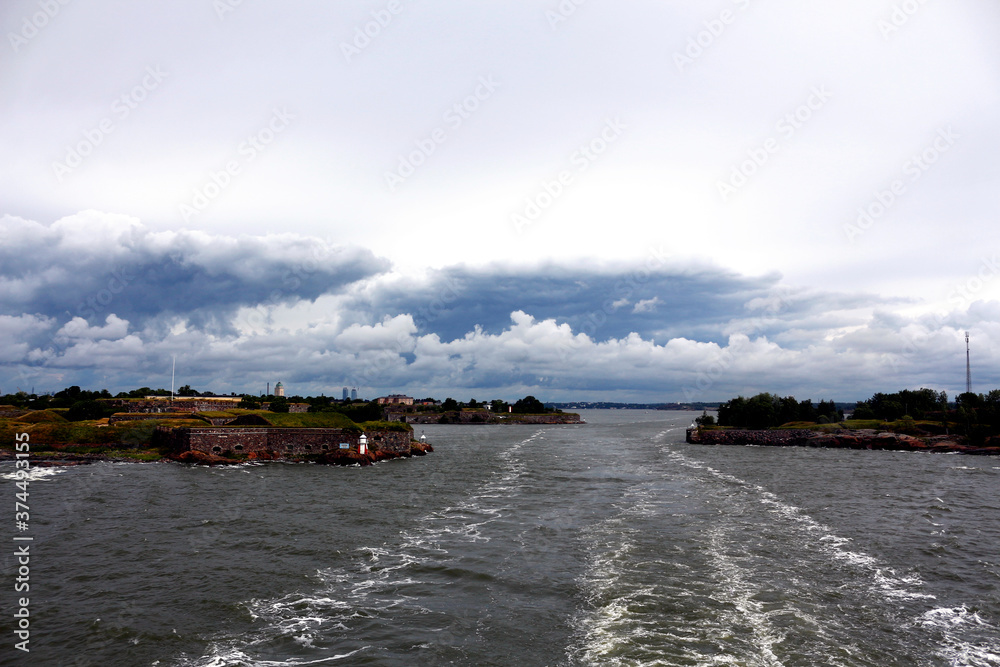 Beautiful view from the stern of the ferry to the old fortress Suomenlinna, Helsinki, Finland. Beautiful storm clouds.